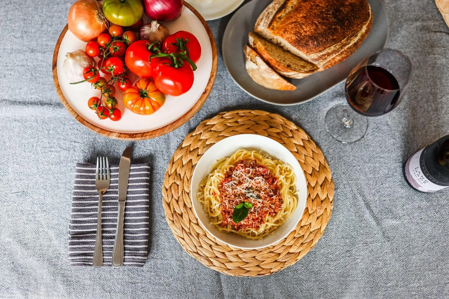 Bowl of spaghetti bolognese with fresh tomatoes and bread